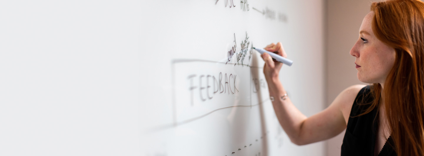 Woman writing out a plan of action on a whiteboard